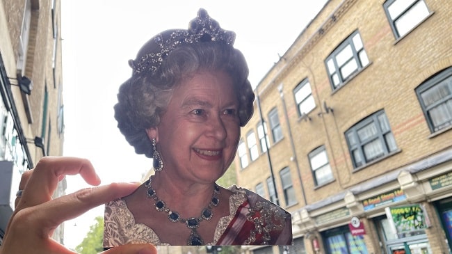 תמונה של המלכה אליזבת' על רקע רחוב בלונדון