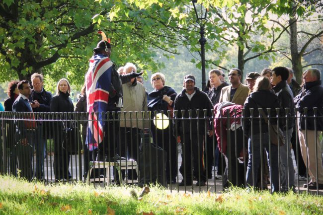 נואם לובש דגל בריטניה ומדים מדבר עם קהל בהייד פארק בלונדון