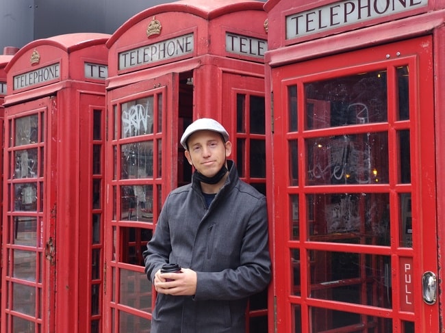 אייל כהן על רקע תאי הטלפון האיקוניים של לונדון