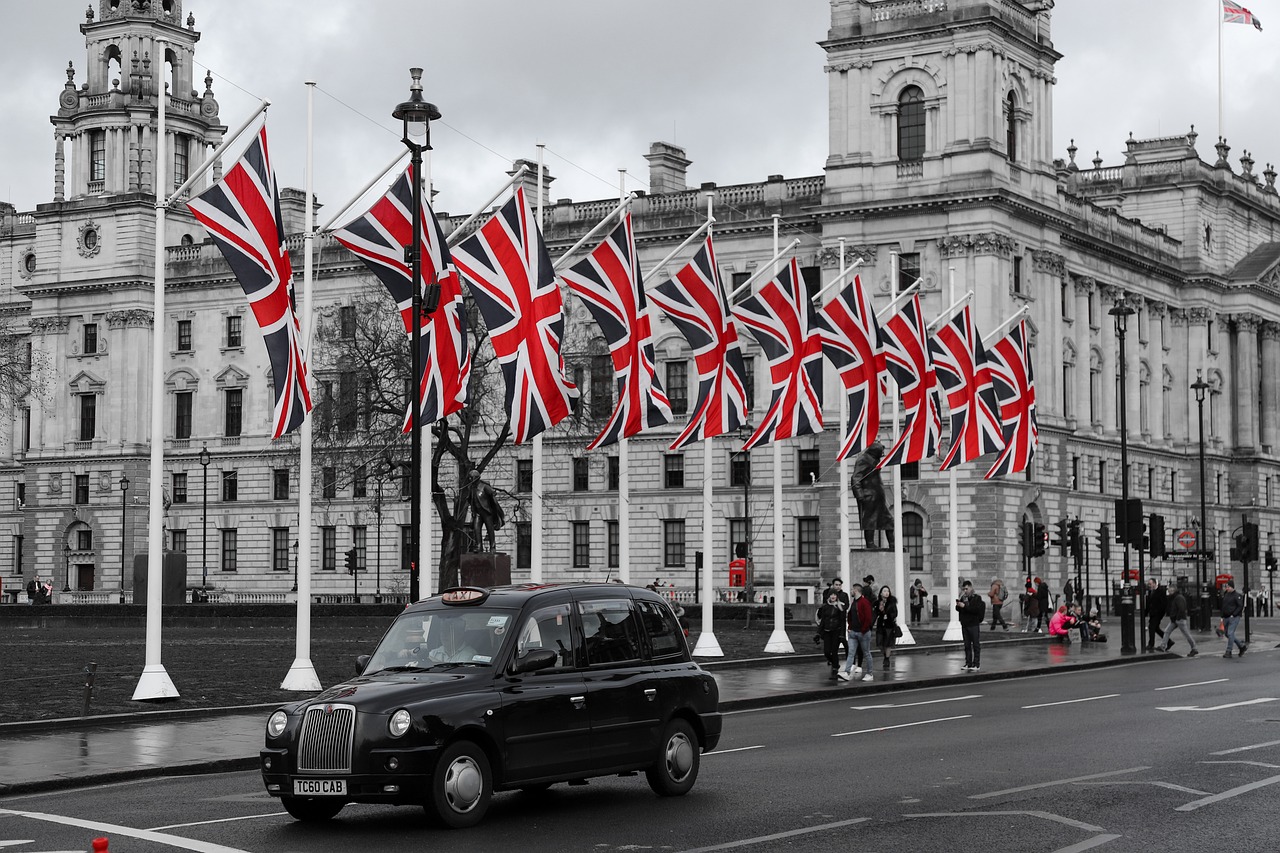 מונית שחורה בלונדון על רקע דגלי אנגליה