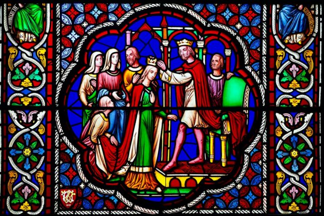 Vibrant stained glass artwork in an English cathedral showcasing a regal coronation with intricate designs.