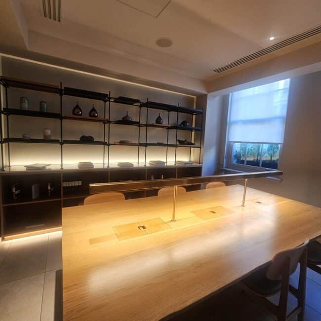 חדר הישיבות עם מדפי עץ וכלי קרמיקה יפניים